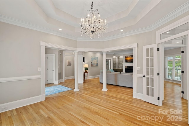 17308 Players Ridge Dr, Cornelius, NC 28031 - spare room featuring ornate columns, light wood-type flooring, ornamental molding, baseboards, and a tray ceiling