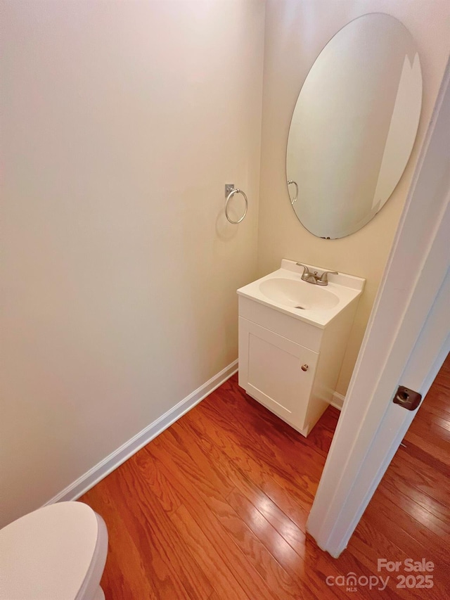 11624 Truan Ln, Cornelius, NC 28031 - half bathroom featuring wood finished floors, vanity, baseboards, and toilet