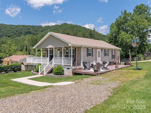 16 Sams Branch Rd, Candler, NC 28715 - view of front of house featuring a front lawn, a porch, a wooded view, and roof with shingles