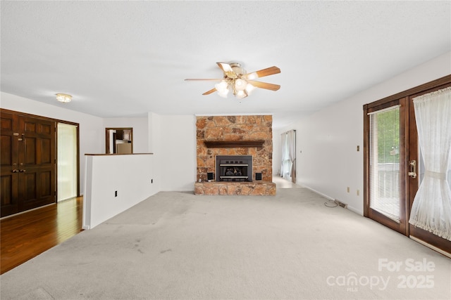 2309 Potter Rd S, Waxhaw, NC 28173 - unfurnished living room featuring carpet flooring, a ceiling fan, a stone fireplace, and baseboards