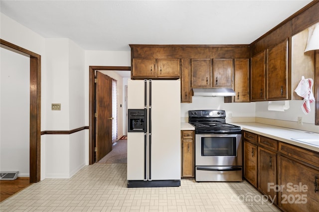 2309 Potter Rd S, Waxhaw, NC 28173 - kitchen with white fridge with ice dispenser, electric stove, under cabinet range hood, light countertops, and brick patterned flooring