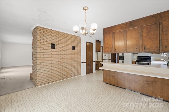 2309 Potter Rd S, Waxhaw, NC 28173 - kitchen featuring stainless steel electric stove, a chandelier, brick wall, light countertops, and hanging light fixtures