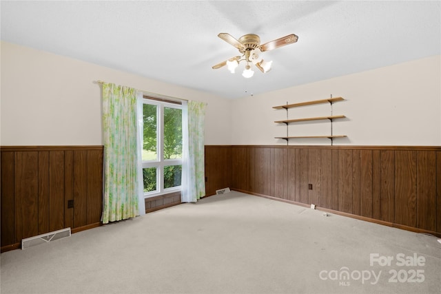 2309 Potter Rd S, Waxhaw, NC 28173 - spare room with a wainscoted wall, wooden walls, a ceiling fan, and carpet flooring