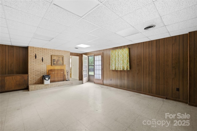 2309 Potter Rd S, Waxhaw, NC 28173 - unfurnished living room featuring tile patterned floors, a drop ceiling, and wooden walls