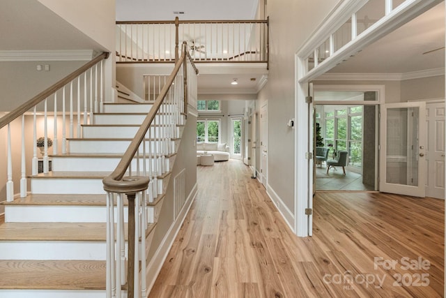 2006 Sandy Pond Ln, Waxhaw, NC 28173 - stairway featuring ornamental molding, wood finished floors, a towering ceiling, baseboards, and french doors