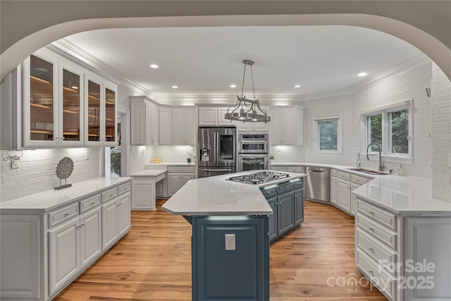 2006 Sandy Pond Ln, Waxhaw, NC 28173 - kitchen featuring appliances with stainless steel finishes, tasteful backsplash, a center island, crown molding, and a sink