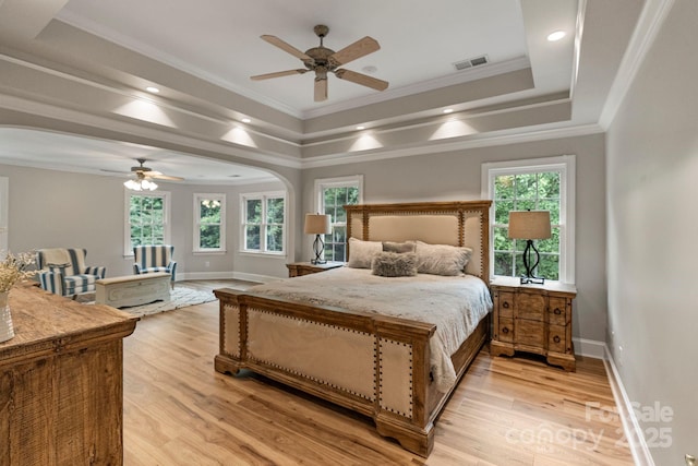 2006 Sandy Pond Ln, Waxhaw, NC 28173 - bedroom with arched walkways, a tray ceiling, light wood-type flooring, crown molding, and baseboards
