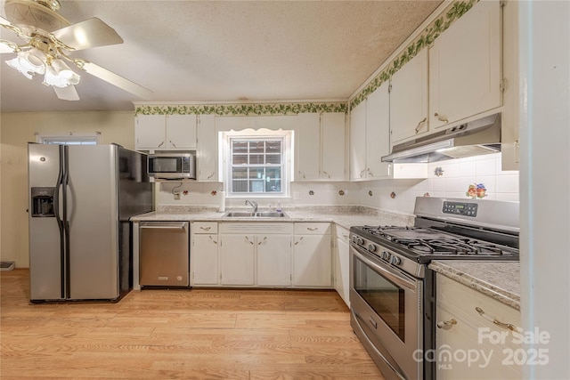 5840 Potter Rd, Matthews, NC 28104 - kitchen with appliances with stainless steel finishes, under cabinet range hood, light countertops, a ceiling fan, and a textured ceiling