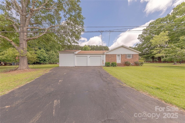 5840 Potter Rd, Matthews, NC 28104 - single story home with asphalt driveway, brick siding, a garage, and a front lawn