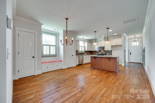 750 Waterscape Ct, Rock Hill, SC 29730 - kitchen featuring stainless steel appliances, a chandelier, white cabinets, light wood finished floors, and ornamental molding