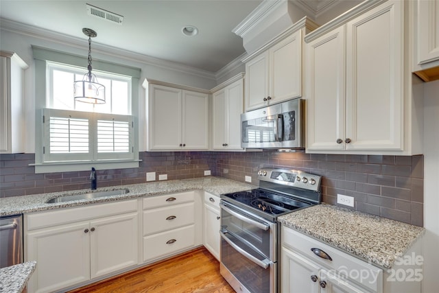 750 Waterscape Ct, Rock Hill, SC 29730 - kitchen featuring stainless steel appliances, a sink, light stone countertops, decorative backsplash, and ornamental molding