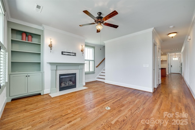 750 Waterscape Ct, Rock Hill, SC 29730 - unfurnished living room with stairs, a ceiling fan, light wood-style floors, a fireplace with flush hearth, and ornamental molding