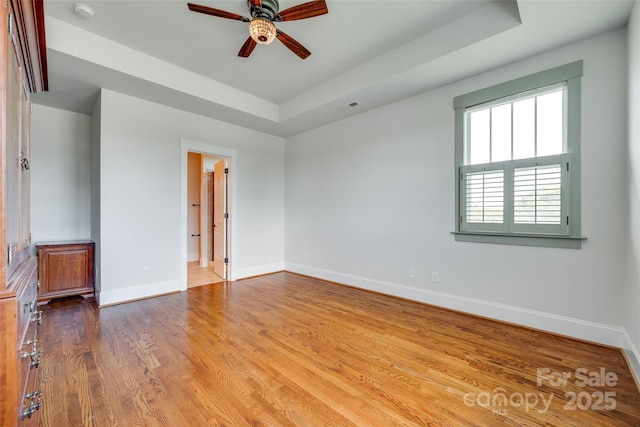 750 Waterscape Ct, Rock Hill, SC 29730 - spare room featuring a ceiling fan, baseboards, wood finished floors, and a tray ceiling