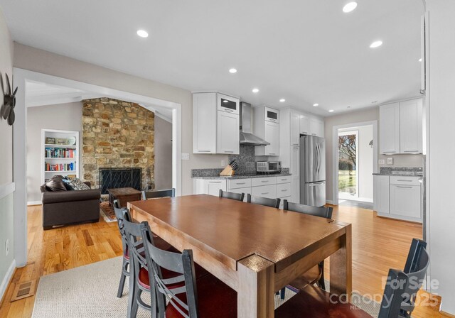 5153 Glenwood St, Sherrills Ford, NC 28673 - dining space with light wood-type flooring, a stone fireplace, recessed lighting, and baseboards