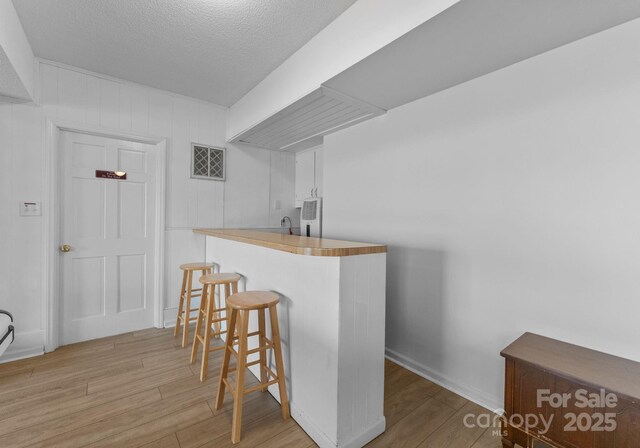 5153 Glenwood St, Sherrills Ford, NC 28673 - indoor wet bar featuring wood finished floors, a textured ceiling, and baseboards