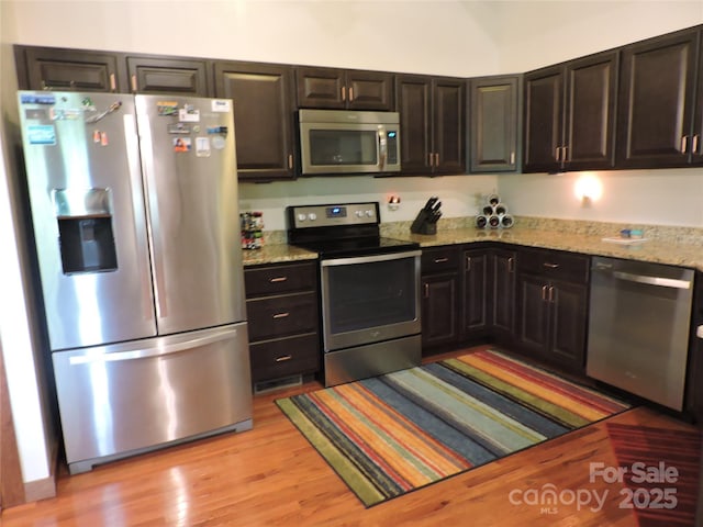 235 Red Oak Ln, Burnsville, NC 28714 - kitchen with appliances with stainless steel finishes, light wood finished floors, and light stone countertops