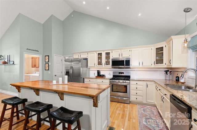 20 Grove Garden Ave, Candler, NC 28715 - kitchen featuring appliances with stainless steel finishes, a sink, separate washer and dryer, high vaulted ceiling, and butcher block countertops