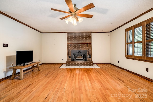 1142 Foxberry Rd, Lincolnton, NC 28092 - unfurnished living room featuring ornamental molding, a wood stove, light wood-type flooring, baseboards, and ceiling fan