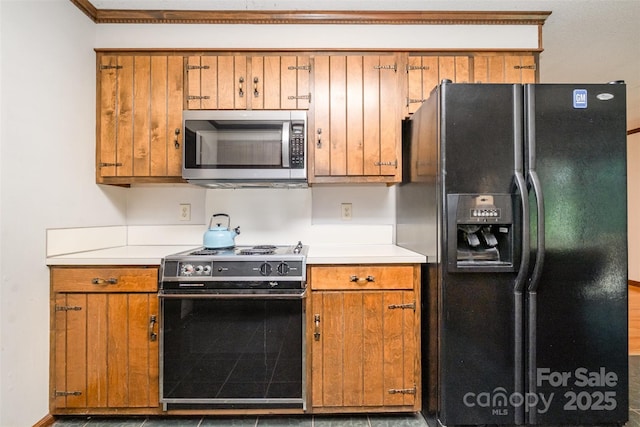 1142 Foxberry Rd, Lincolnton, NC 28092 - kitchen featuring stainless steel microwave, black refrigerator with ice dispenser, electric stove, brown cabinetry, and light countertops