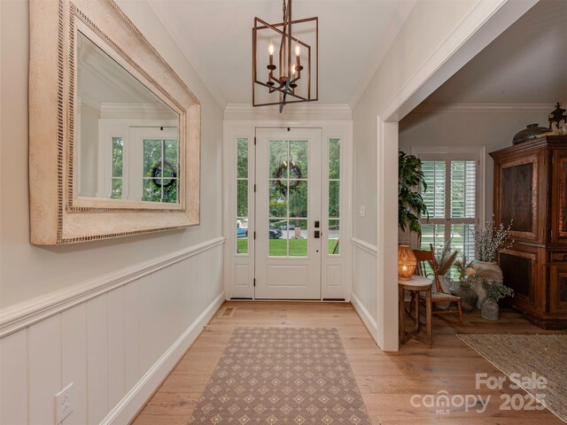 4201 Quail Hunt Ln, Charlotte, NC 28226 - entryway with a chandelier, light wood-style floors, wainscoting, crown molding, and a decorative wall