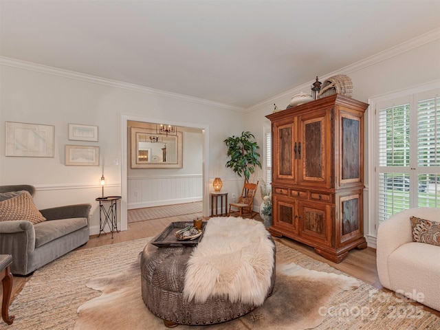 4201 Quail Hunt Ln, Charlotte, NC 28226 - living room featuring light wood-type flooring, crown molding, a chandelier, baseboards, and a wainscoted wall