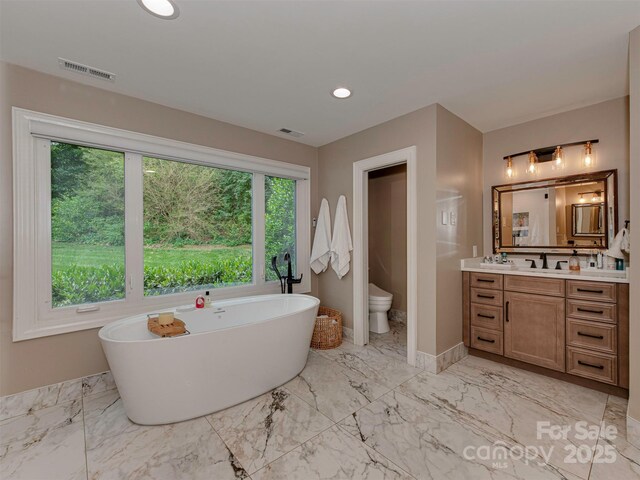 4201 Quail Hunt Ln, Charlotte, NC 28226 - bathroom with vanity, a freestanding tub, toilet, marble finish floors, and recessed lighting