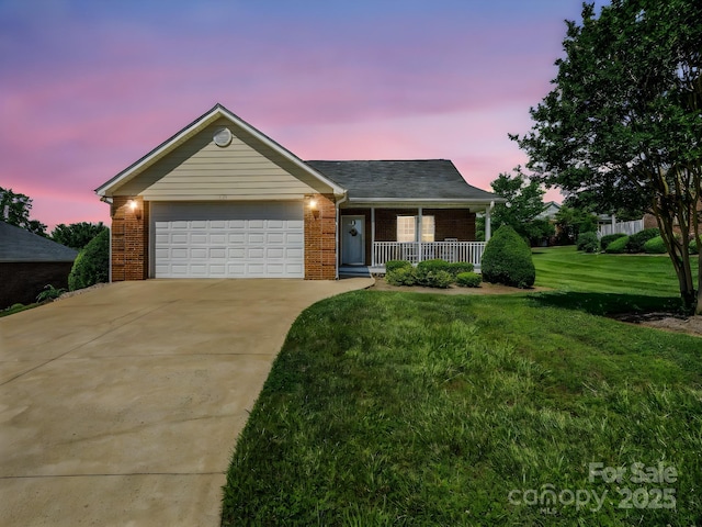 116 Memphis Way, Spindale, NC 28160 - ranch-style home with a porch, brick siding, driveway, a lawn, and an attached garage