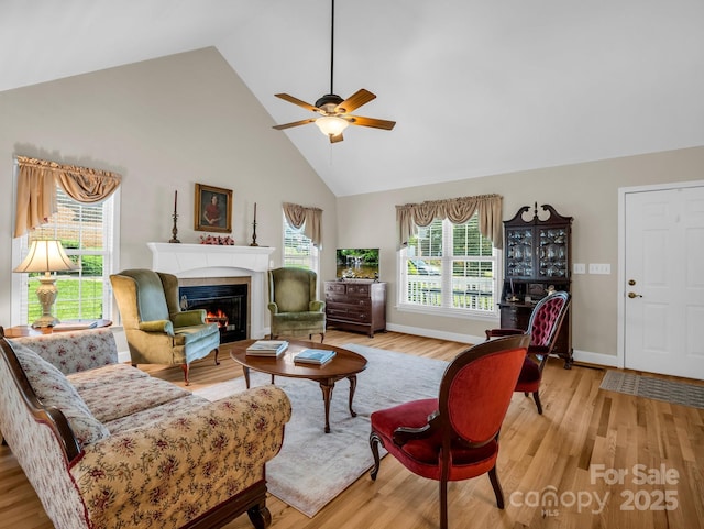 116 Memphis Way, Spindale, NC 28160 - living room with high vaulted ceiling, ceiling fan, a tiled fireplace, light wood-type flooring, and baseboards