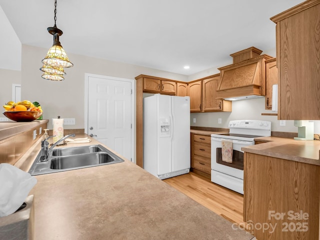 116 Memphis Way, Spindale, NC 28160 - kitchen featuring white appliances, a sink, premium range hood, light wood finished floors, and hanging light fixtures