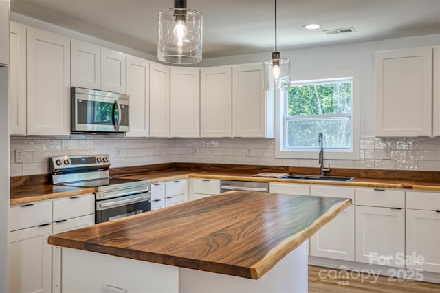 2934 Drummond St, Connelly Springs, NC 28612 - kitchen featuring butcher block countertops, appliances with stainless steel finishes, a sink, white cabinets, and recessed lighting