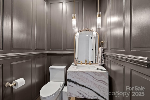 1625 Bibury Ln, Charlotte, NC 28211 - half bathroom featuring a decorative wall, vanity, and toilet