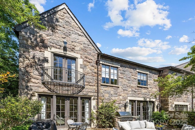 1625 Bibury Ln, Charlotte, NC 28211 - rear view of house with french doors, a balcony, stone siding, and exterior kitchen