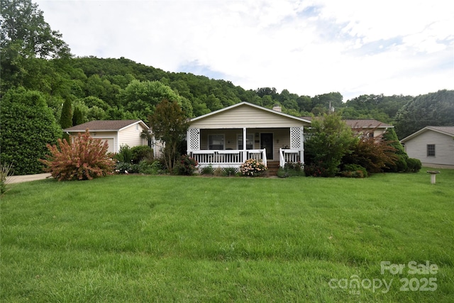 74 Sunflower Ln, Waynesville, NC 28785 - view of front of house with a porch, a front yard, and a wooded view
