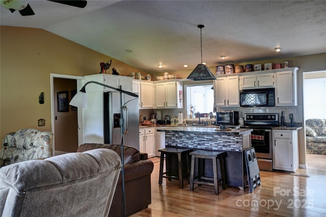 74 Sunflower Ln, Waynesville, NC 28785 - kitchen with stainless steel appliances, open floor plan, white cabinets, a breakfast bar area, and light wood-style floors