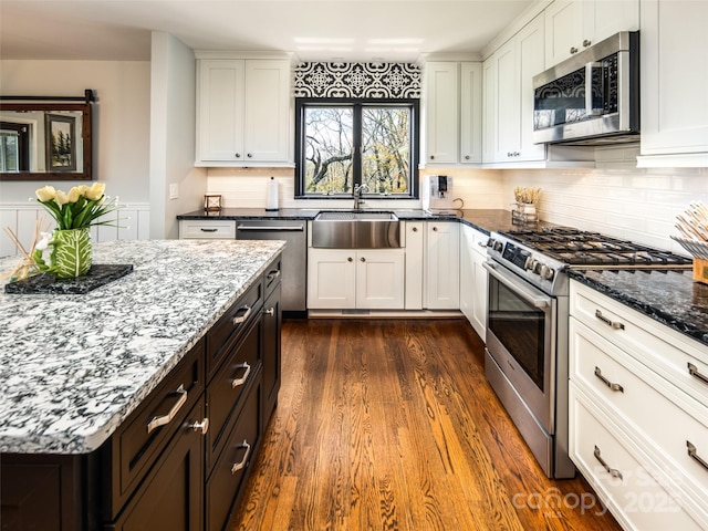 4344 Eagles Nest Rd, Waynesville, NC 28786 - kitchen with stainless steel appliances, a sink, dark stone counters, dark wood finished floors, and white cabinets