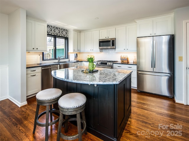 4344 Eagles Nest Rd, Waynesville, NC 28786 - kitchen featuring appliances with stainless steel finishes, a center island, dark wood-style flooring, and dark stone countertops