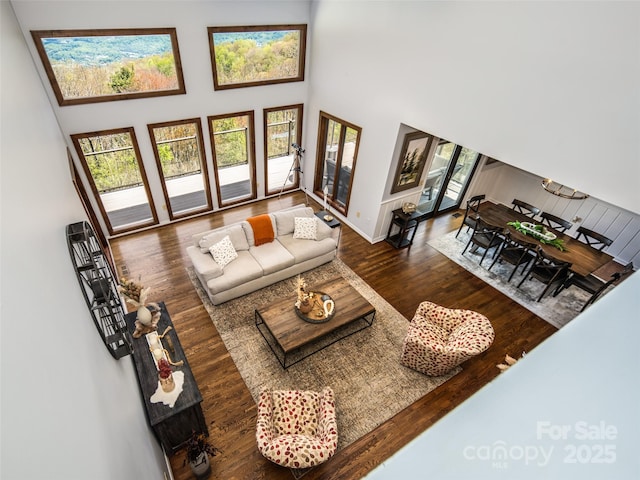 4344 Eagles Nest Rd, Waynesville, NC 28786 - living area with wood finished floors, a towering ceiling, and baseboards