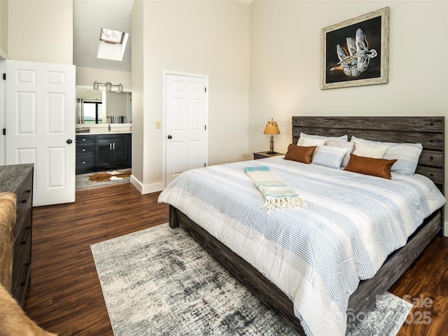 4344 Eagles Nest Rd, Waynesville, NC 28786 - bedroom featuring a skylight, dark wood-type flooring, baseboards, a sink, and connected bathroom