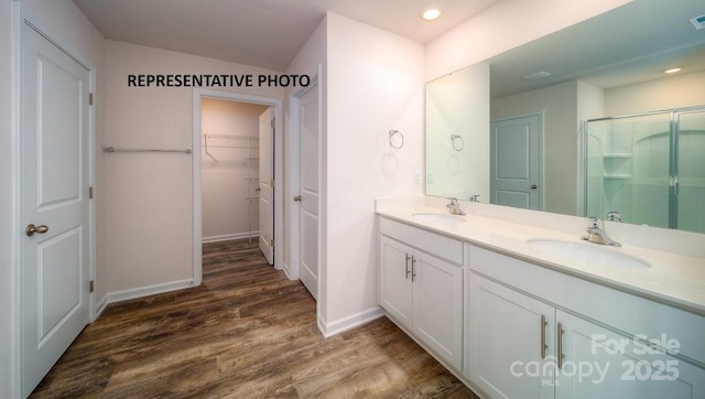 921 Two Brothers Ln, York, SC 29745 - bathroom featuring double vanity, wood finished floors, a stall shower, a walk in closet, and recessed lighting