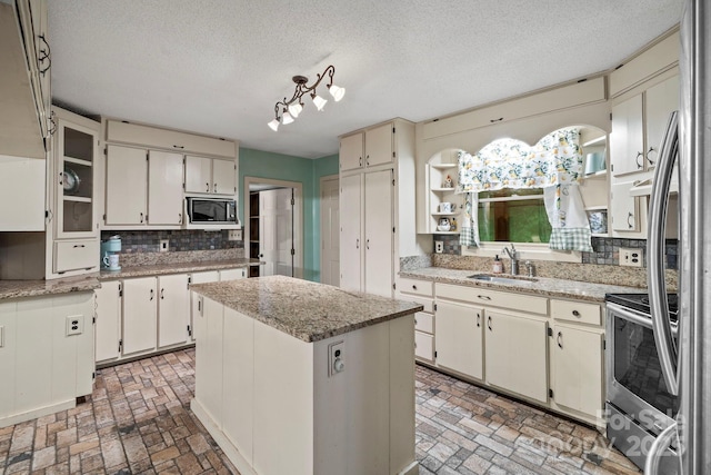 14518 Big Laurel Rd, Mars Hill, NC 28754 - kitchen featuring built in microwave, a sink, brick patterned floors, tasteful backsplash, and a textured ceiling