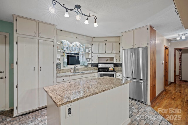 14518 Big Laurel Rd, Mars Hill, NC 28754 - kitchen featuring stainless steel appliances, open shelves, a textured ceiling, a sink, and cream cabinets