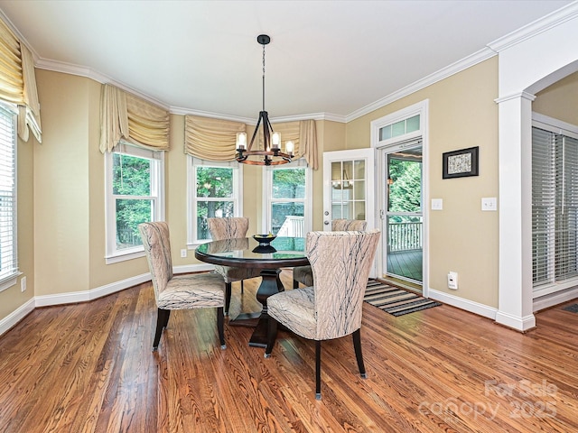 2406 Tarleton Twins Ter, Charlotte, NC 28270 - dining area with a chandelier, baseboards, wood finished floors, ornamental molding, and ornate columns