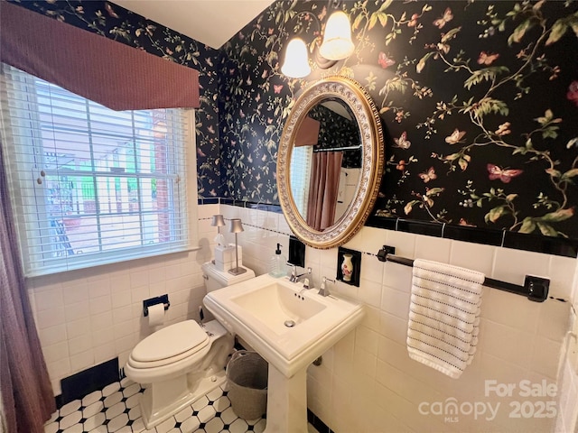 303 Wade E Vannoy Dr, West Jefferson, NC 28694 - bathroom with a wainscoted wall, toilet, wallpapered walls, tile walls, and a shower with shower curtain