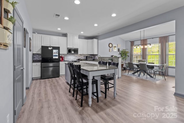 1725 Mill Creek Ln SW, Concord, NC 28025 - kitchen with smart refrigerator, stainless steel microwave, tasteful backsplash, white cabinets, and recessed lighting