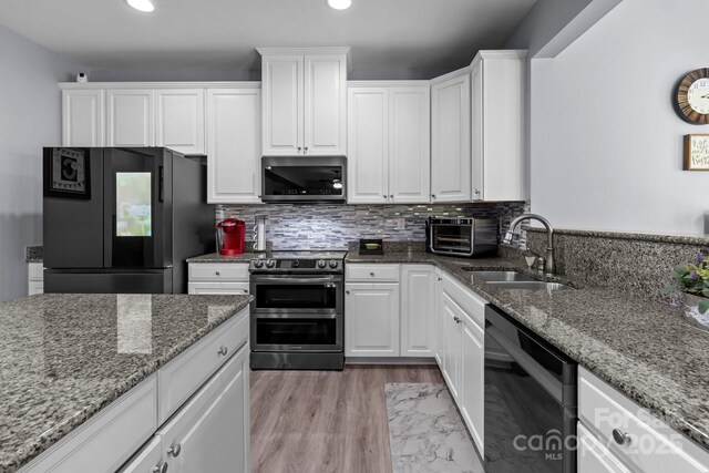 1725 Mill Creek Ln SW, Concord, NC 28025 - kitchen with black appliances, a sink, white cabinets, light stone counters, and recessed lighting