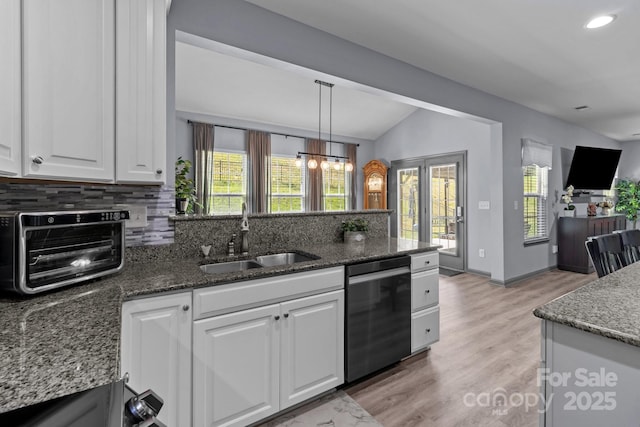 1725 Mill Creek Ln SW, Concord, NC 28025 - kitchen featuring dishwashing machine, a sink, backsplash, vaulted ceiling, and white cabinetry