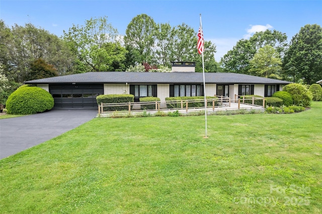 225 Valley View Ter, Waynesville, NC 28786 - view of front facade with an attached garage, driveway, a front yard, brick siding, and a chimney