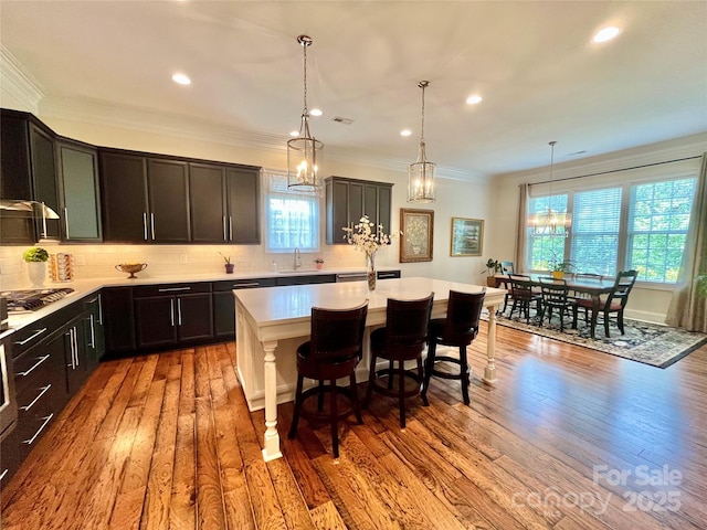 1025 N Sharon Amity Rd, Charlotte, NC 28211 - kitchen with light countertops, a center island with sink, stainless steel gas stovetop, tasteful backsplash, and recessed lighting