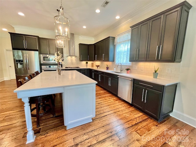 1025 N Sharon Amity Rd, Charlotte, NC 28211 - kitchen featuring stainless steel appliances, a sink, a breakfast bar area, light wood finished floors, and wall chimney exhaust hood