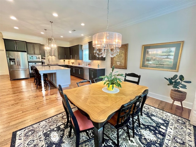 1025 N Sharon Amity Rd, Charlotte, NC 28211 - dining area featuring a chandelier, crown molding, light wood finished floors, recessed lighting, and baseboards